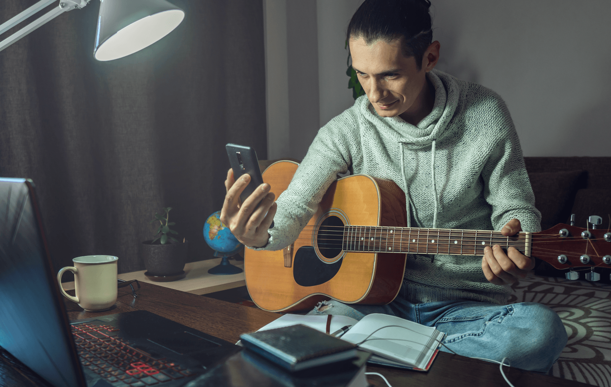 Guitarist in tracking room looking at his phone