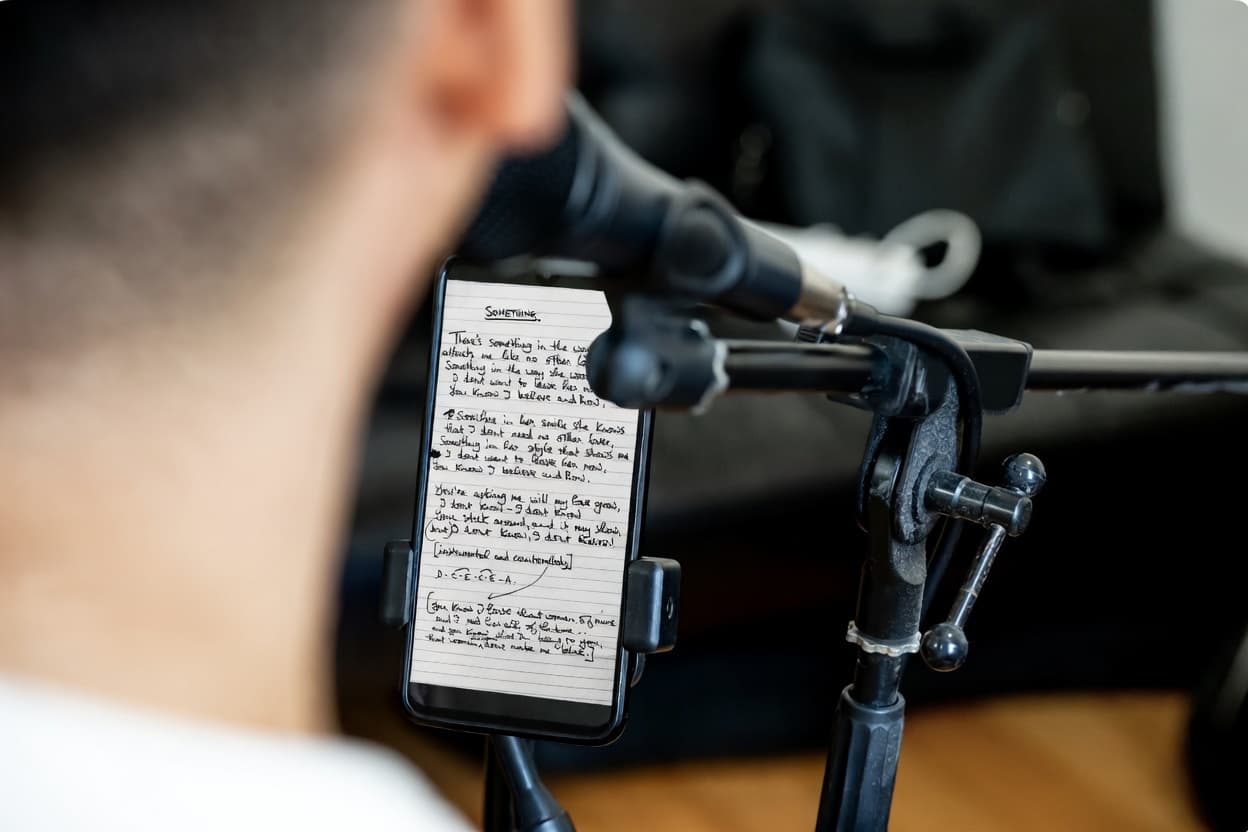Singer tracking in studio looking at her phone